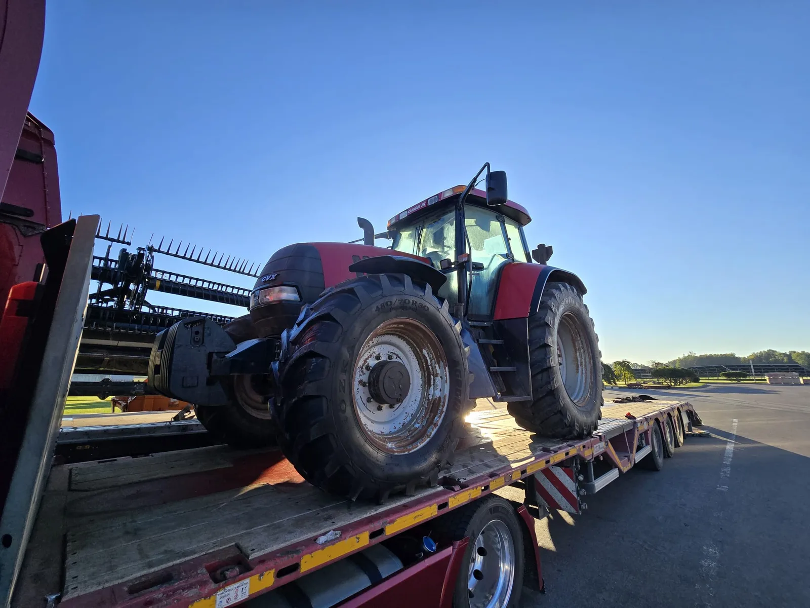 Ciągnik rolniczy Case IH na naczepie niskopodwoziowej Gonera Transport